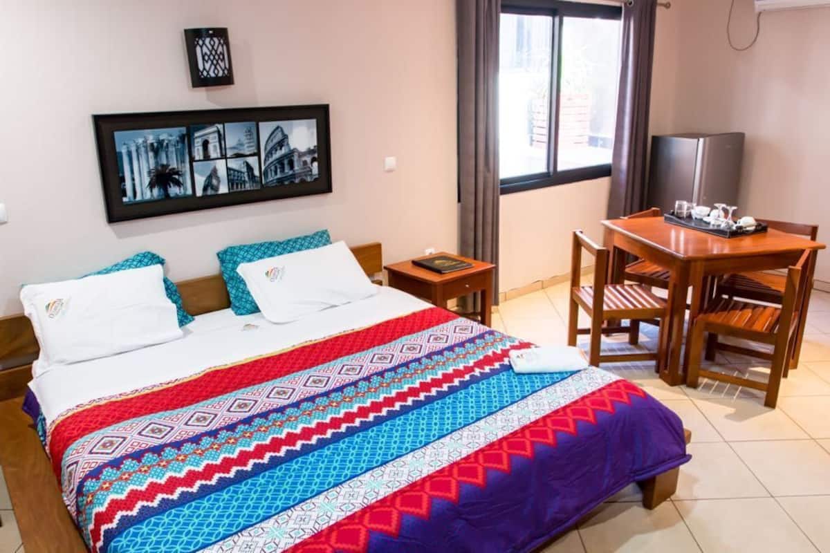 Una habitación de hotel con una cama, un escritorio y una silla.