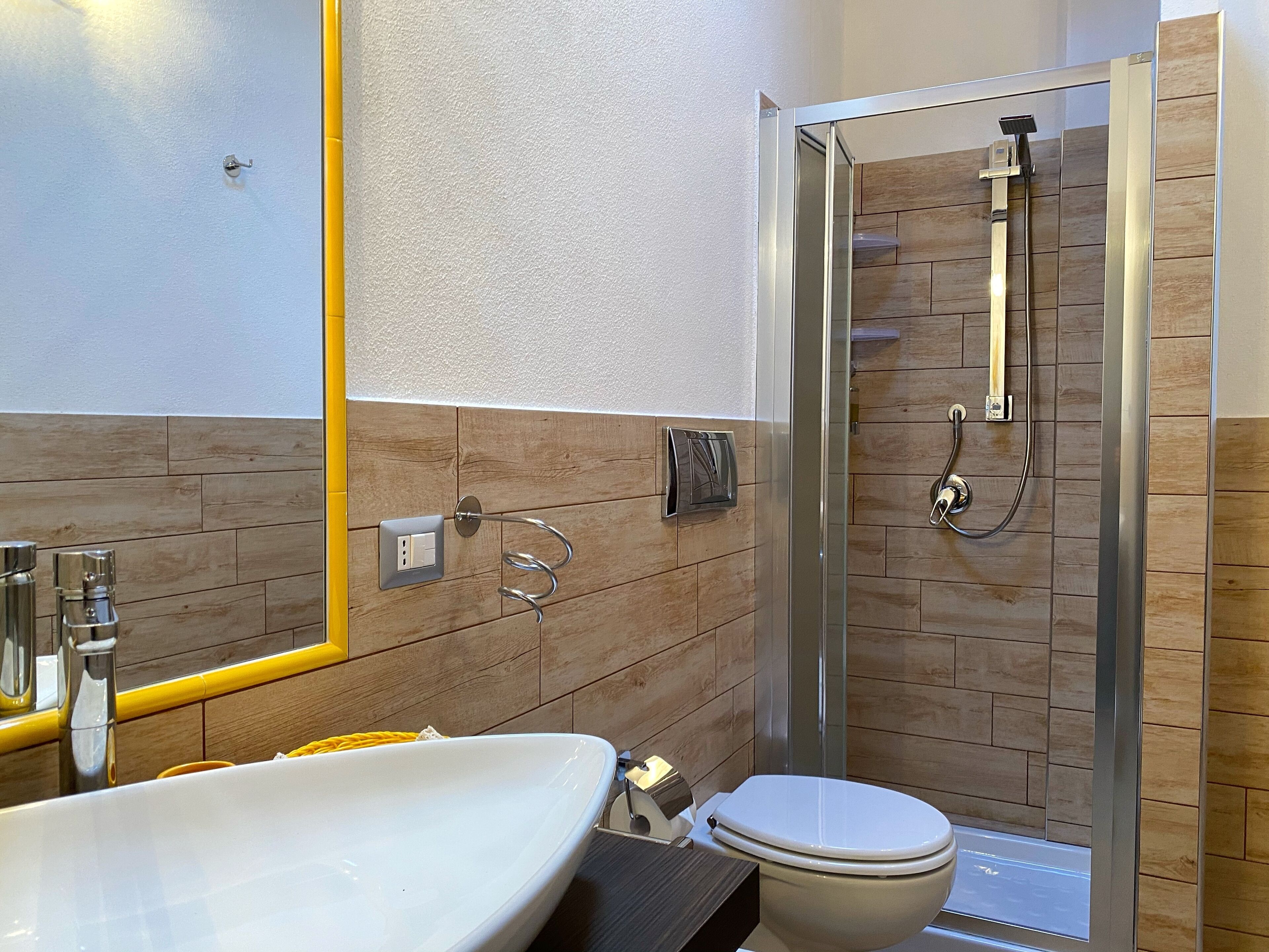 Une salle de bain moderne avec une douche à parois de verre, un lavabo blanc et des toilettes.