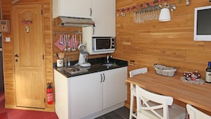 A compact kitchen with white cabinets, a microwave, and a small dining table with chairs. - Studio for 2 with balcony in the center of Avoriaz (Avoriaz)