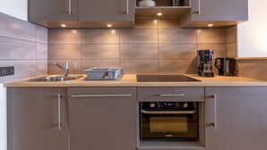 A modern kitchen with a built-in oven, a sink, and a coffee maker. - Beautiful 2-room apartment for 4 in Avoriaz, Southeast balcony (Avoriaz)