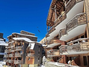Un ensemble de bâtiments en bois dotés de balcons, probablement un hébergement situé dans une station de ski.