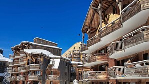 A cluster of wooden chalet-style buildings with balconies and snow on the roofs, indicating a winter setting. - Charming renovated apartment 2 rooms, balcony, WiFi (Avoriaz)