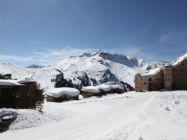 Un paysage montagneux enneigé, avec des bâtiments et un ciel dégagé.
