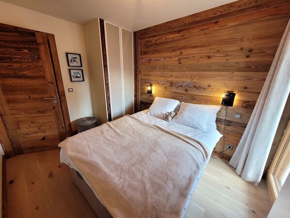 Cozy retreat with a comfortable bed, wooden headboard, and framed artwork.