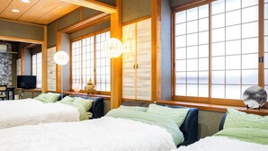 A traditional Japanese-style room with tatami flooring, a low table with a television, and a large shoji screen window. - Glamping Hoshigaminomori (Nakatsugawa)