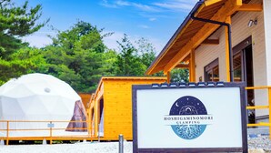 A glamping site with a dome tent and a wooden building with a sign reading "Hoshigaminomori Glamping". - Glamping Hoshigaminomori (Nakatsugawa)