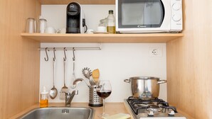 Angolo cottura funzionale con microonde, macchina del caffè, lavello e fornelli.