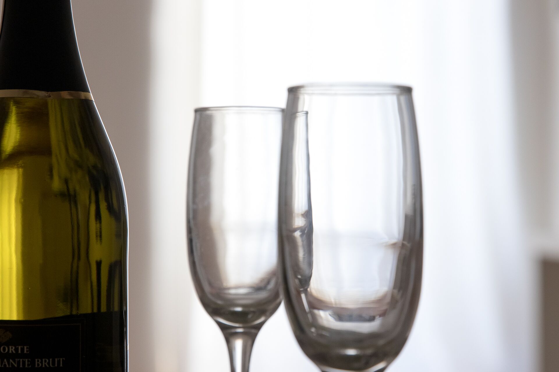 A bottle of wine and two empty wine glasses.