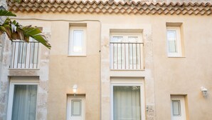 Un edificio con diverse finestre, alcune dotate di inferriate, e un lampadario a parete.