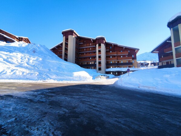 A multi-story hotel with balconies, surrounded by snow.