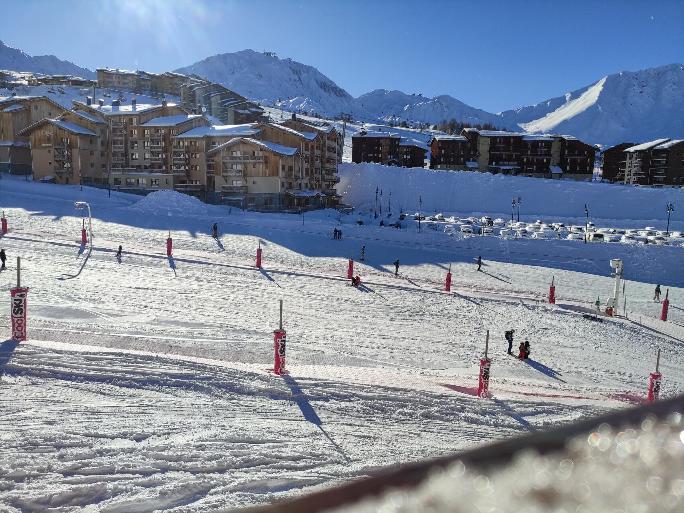 Ein Skigebiet mit mehreren Holzhütten und einer Skipiste.