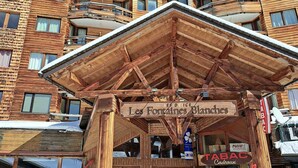 A wooden chalet with a sign reading "Les Fontaines Blanches".