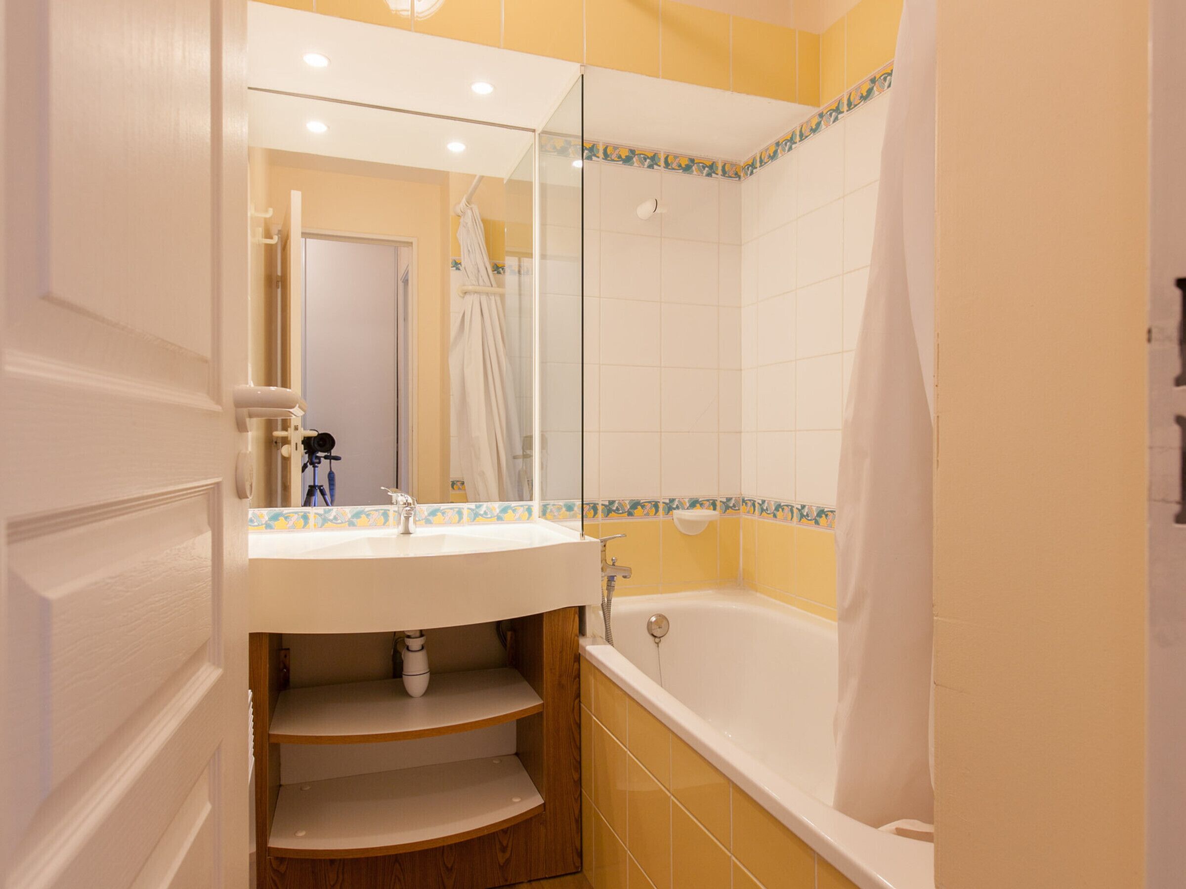 Une salle de bain avec un lavabo, un miroir et une baignoire.