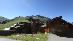Un bâtiment en bois avec une enseigne portant l’inscription « SEPIA », le tout sur fond de paysage montagneux.