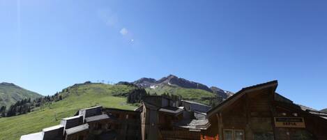 A wooden building with a sign reading "SEPIA" in front of a mountain backdrop.