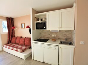 Enjoy a compact space with a kitchenette, sofa, and window for natural light.