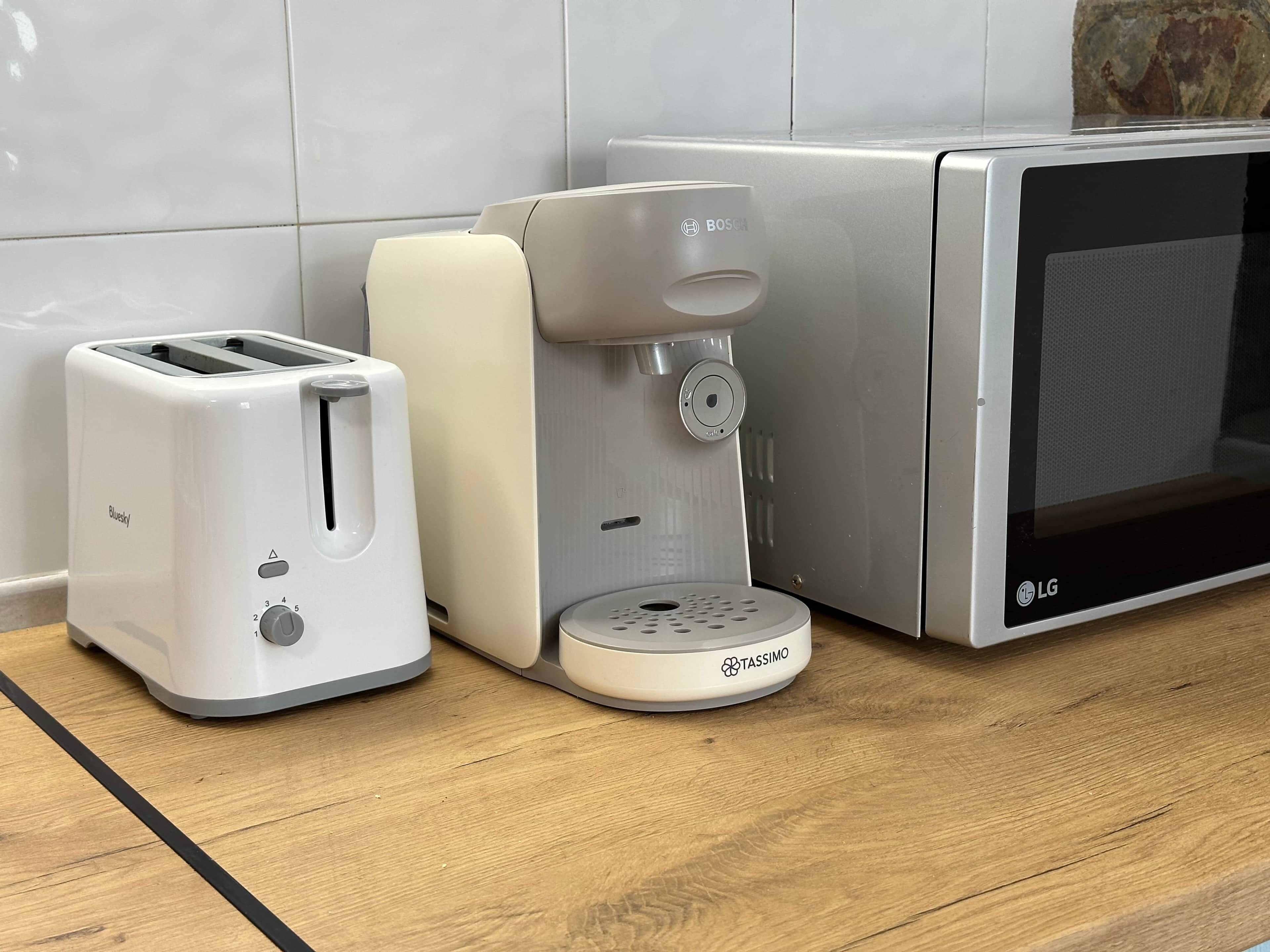 A kitchen with a toaster, a coffee maker, and a microwave.