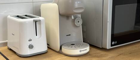 A kitchen with a toaster, a coffee maker, and a microwave.