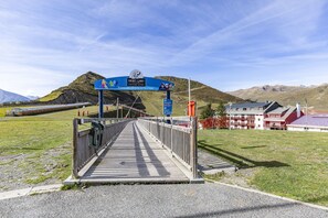 Un pont menant à une région montagneuse, avec un panneau indiquant la direction de Saint-Lary.