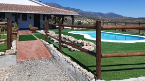 Ein Haus mit Swimmingpool, Terrasse und Bergblick.