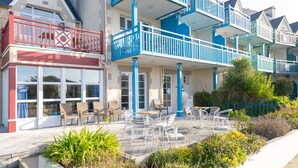 Ein Küstenhotel mit Balkonen, Außenbereich und einem Garten.