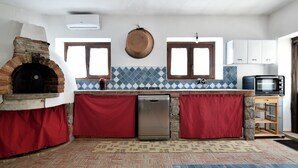 A kitchen with a brick oven, a dishwasher, and a microwave. - Holiday Home 'Ami' with Sea View, Private Terrace and Shared Garden (Arzana)