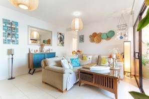 A living room with a sofa, a coffee table, a cabinet, and wall decorations.