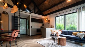 A modern interior with a dining area, kitchen, and living space. - Fantastic luxury forest house | Unwind in nature (Emst)
