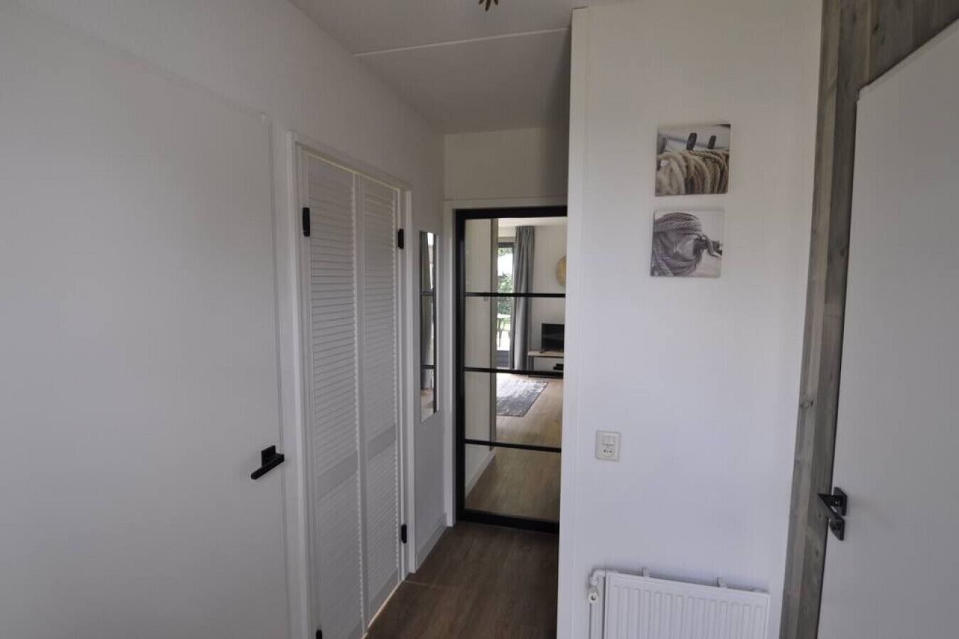 Um corredor com uma porta que dá para um quarto.