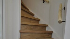 A wooden staircase with a handrail and a wooden handrail on the side. - Comfortable wellness house, everything new, located by the lake. (Ewijk)