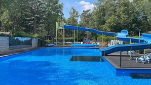 A swimming pool with a blue slide and a small water feature. - VHNT76 · FIKA Luxury holiday home for 4 people at Veluwe (Hoenderloo)