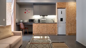 A modern kitchen with grey cabinets, a wooden backsplash, a refrigerator, and a microwave. - Superior Mονόχωρο Διαμέρισμα, Psiri Vibes (Athens)