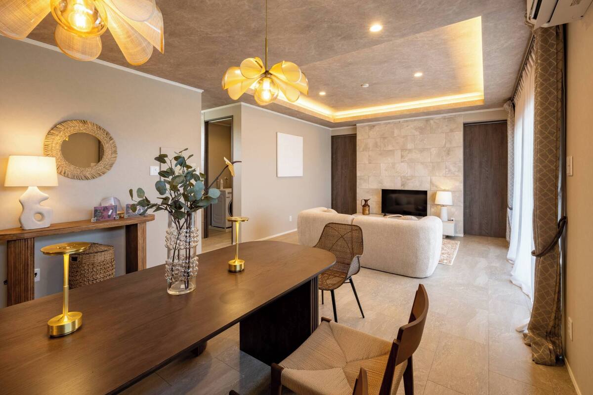 Uma sala de estar moderna com uma mesa de jantar de madeira, um sofá e uma televisão.
