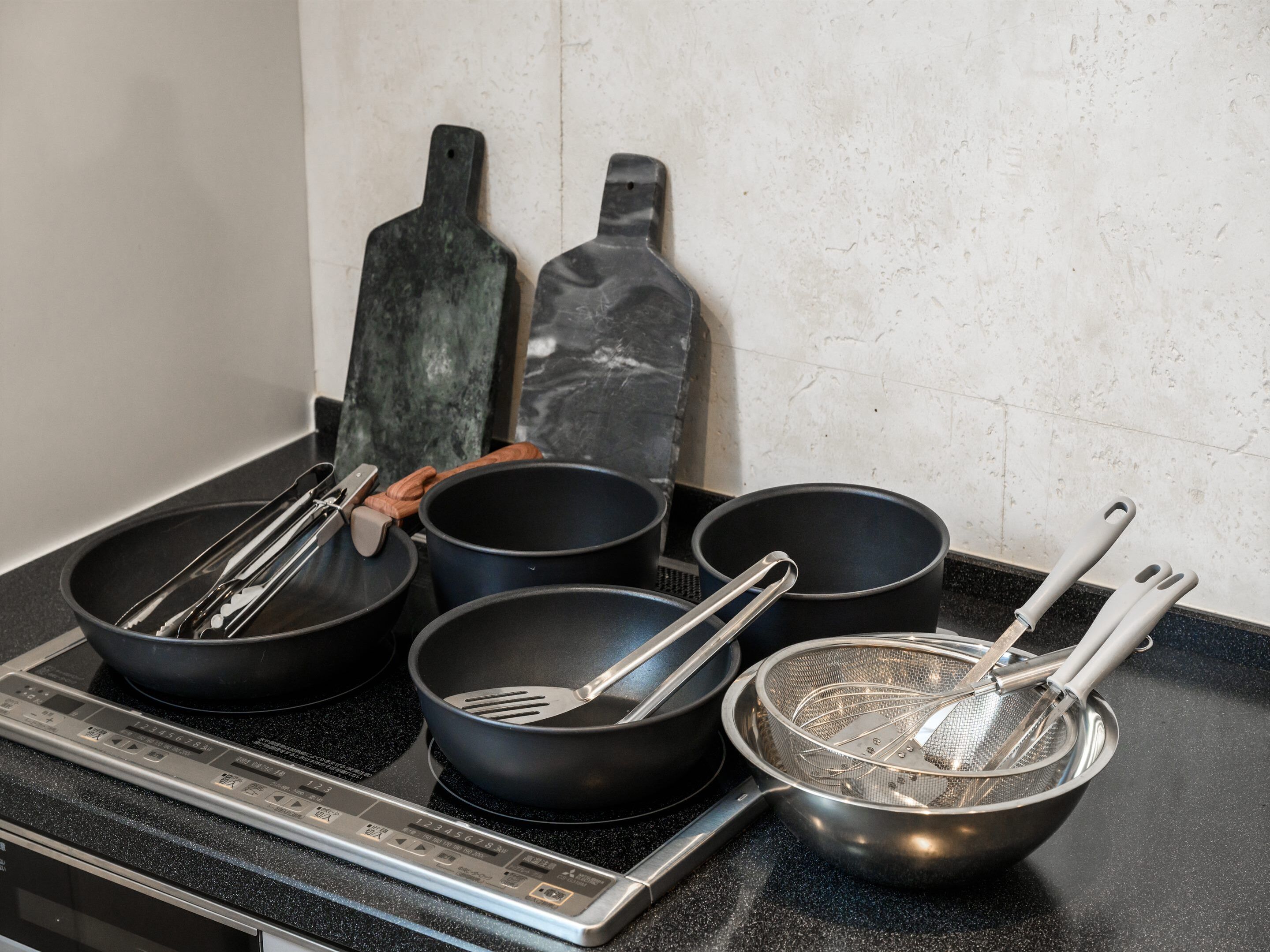 A kitchen counter with various cooking utensils and pans.