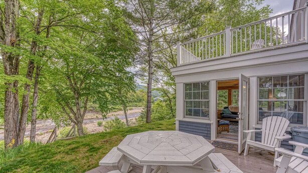 A covered deck with a hexagonal table and benches, overlooking a river and surrounded by trees. - Riverfront House w/ Rooftop Deck! Dog Friendly! (Woodstock)