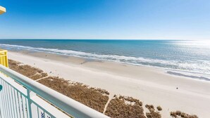 A beach view from a balcony with a railing, sandy beach, and ocean. - Amazing Beachfront 1Bedroom at Bay Watch with Pool (North Myrtle Beach)