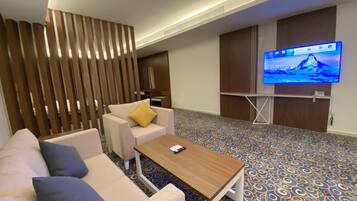 Suite, 1 très grand lit | Coin séjour | Télévision LCD de 20 pouces avec chaînes par satellite, télévision