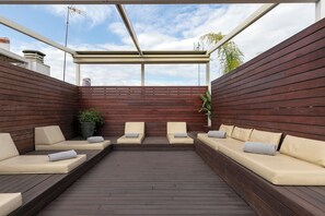 A covered outdoor seating area with wooden walls and cushioned benches. - Holiday Rentals Tempa Museo (Seville)