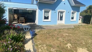 Una casa de dos pisos con garaje, un patio cubierto y un pequeño jardín.