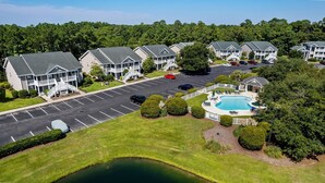 Un quartier résidentiel comprenant plusieurs maisons à deux étages, une piscine et un parking.