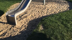 Un terrain de jeux avec un toboggan et un bac à sable.