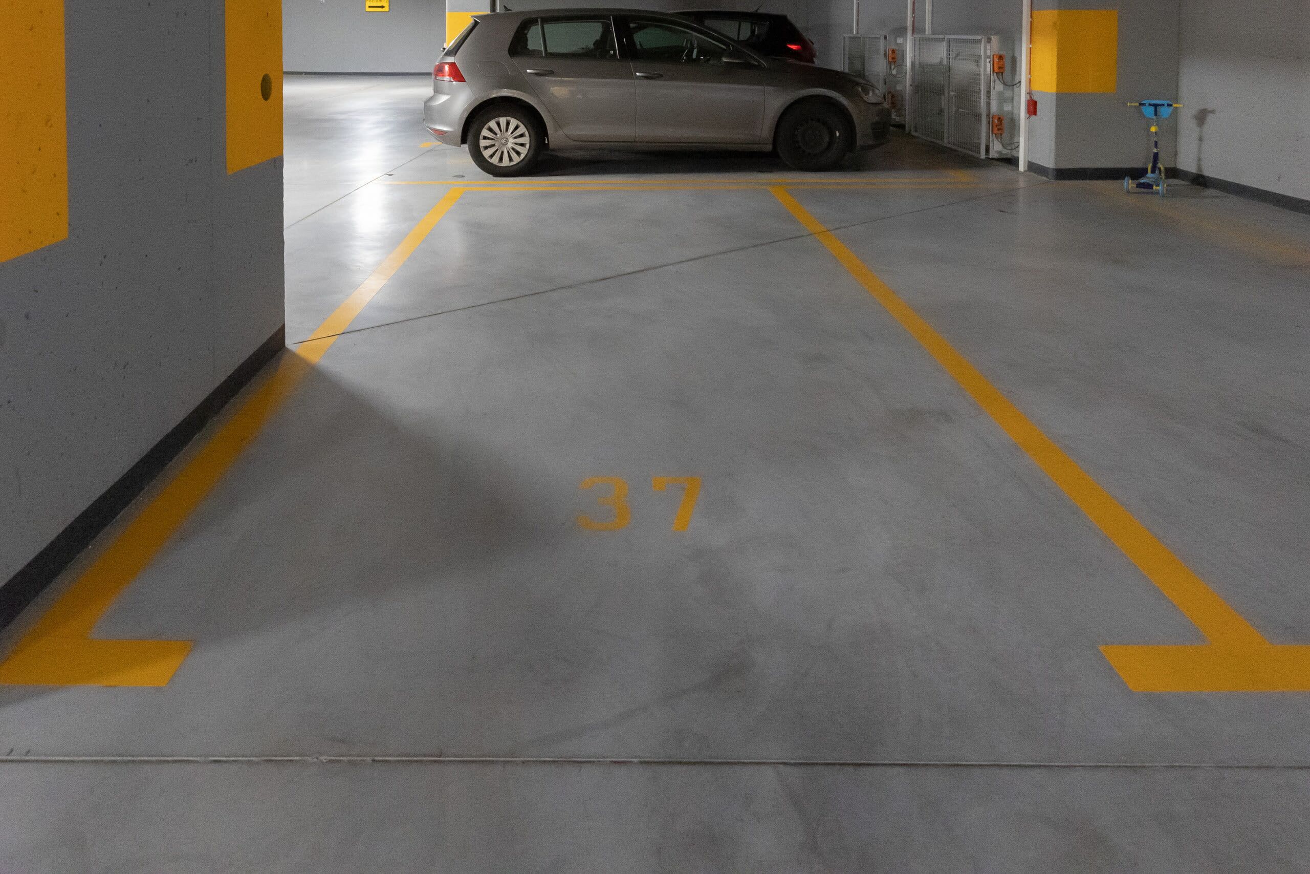 Un parking où une voiture est garée sur une place marquée du numéro 37.