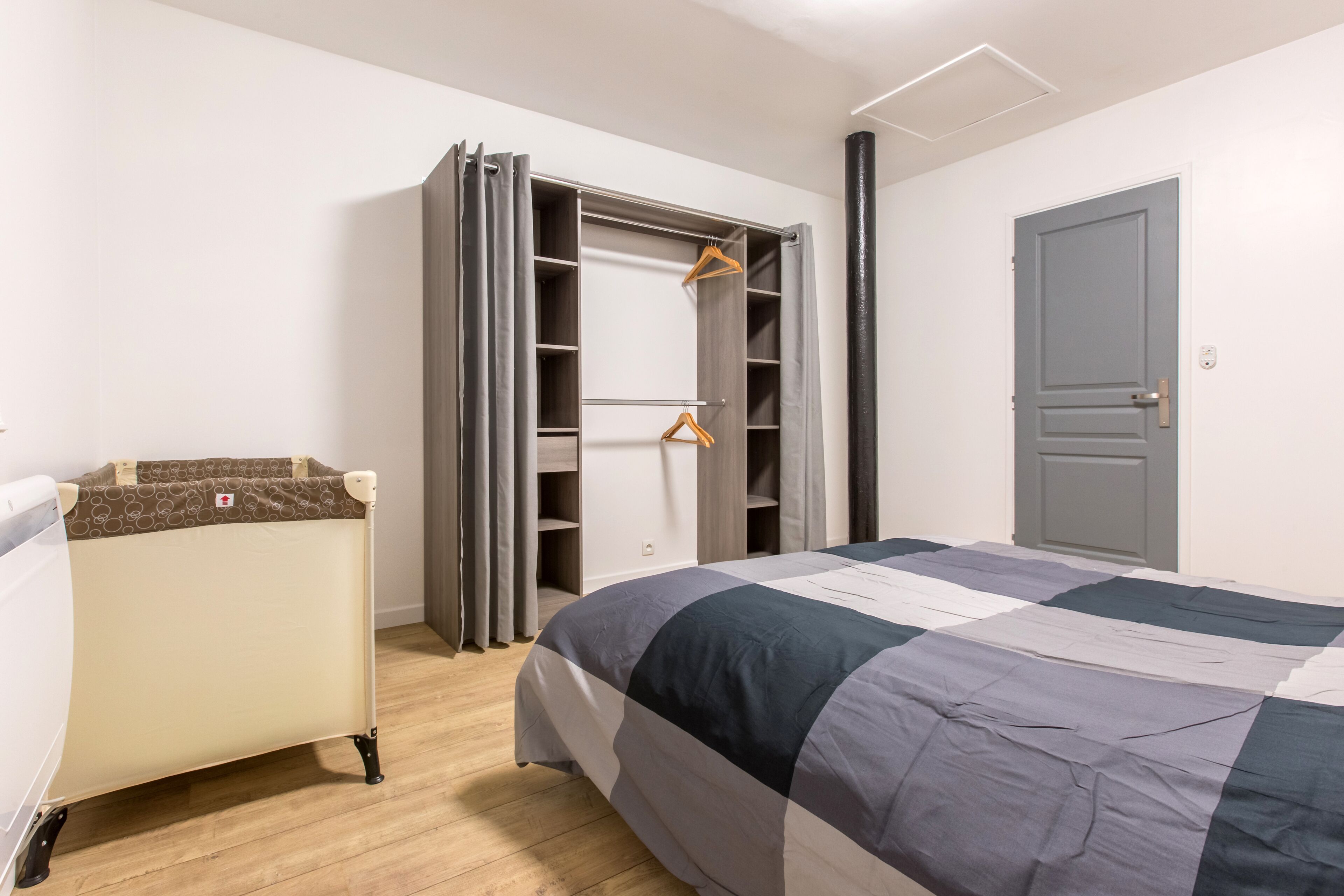Une chambre à coucher avec un lit, une armoire et une petite table.