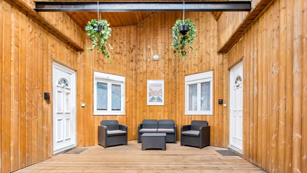 Un intérieur en bois avec trois canapés et deux portes.