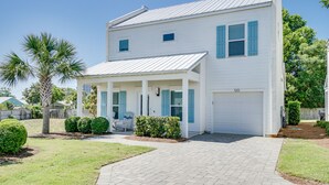 A two-story house with a covered porch, a garage, and a well-maintained lawn. - Seabreeze -Walk to beach! Pet friendly! (Panama City Beach)