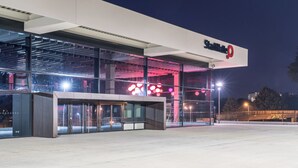 A modern building with a prominent 'Stammate' sign, large glass entrance, and a well-lit facade. - Hotel Am Kai 334 (Rostock)