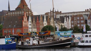 A historic building with a prominent tower and a large clock. - Hotel Am Kai 334 (Rostock)