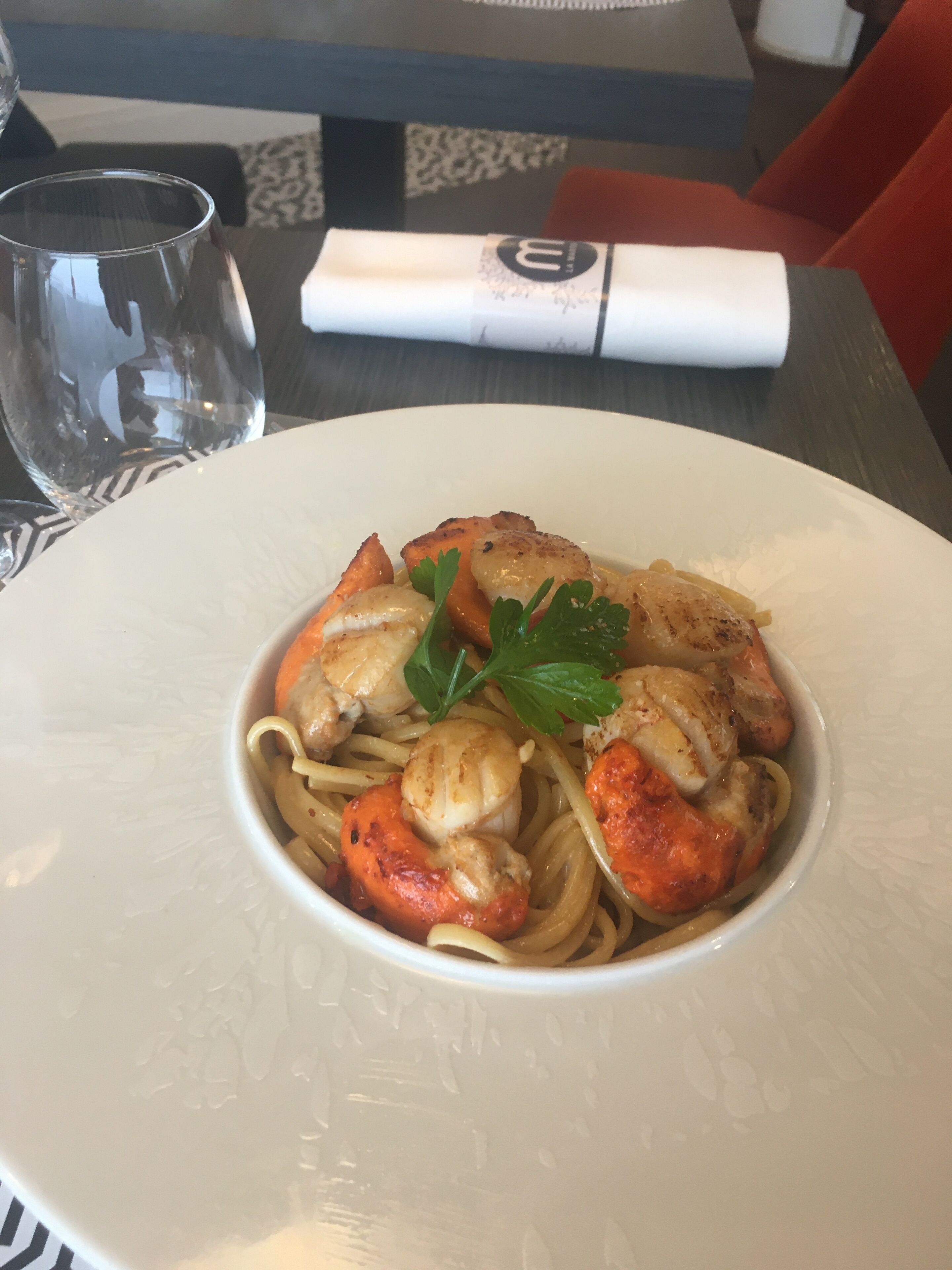 Un plat de pasta amb gambes i guarnició de julivert.