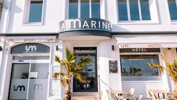 Un immeuble à plusieurs étages, sur lequel on peut lire l’inscription « La Marine », indiquant qu’il abrite un restaurant et un hôtel.