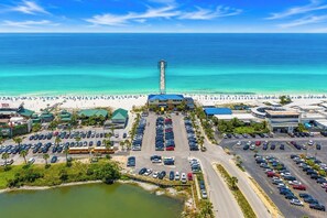 A coastal hotel with a parking lot, beach access, and a view of the ocean.